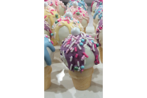 Ice cream cones with colorful icing and sprinkles.